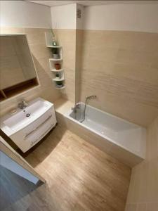 een badkamer met een wit bad en een wastafel bij L'Atelier Marin sur le Port des Marines in Cogolin
