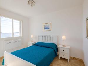 biała sypialnia z łóżkiem i 2 szafkami nocnymi w obiekcie Apartment Les Dauphins-1 by Interhome w miejscowości Sainte-Maxime