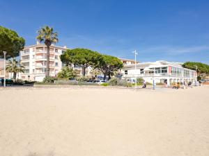 a view of a beach with a building in the background at Apartment Les Dauphins-1 by Interhome in Sainte-Maxime