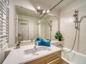 a bathroom with a sink and a mirror at Studio Soyouz Vanguard-19 by Interhome in Le Corbier