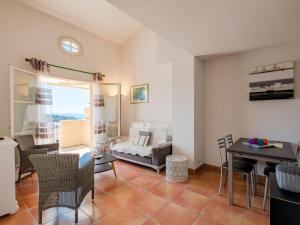 a living room with a couch and a table at Apartment Le Petit Village-2 by Interhome in La Garonnette-Plage