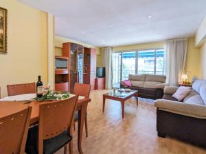 Apartment La Goleta by Interhome في بنيدورم: غرفة معيشة مع أريكة وغرفة طعام