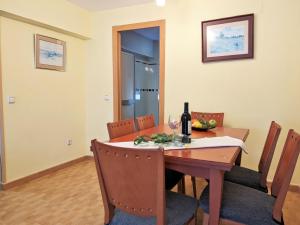 Apartment La Goleta by Interhome في بنيدورم: طاولة غرفة الطعام مع زجاجة من النبيذ عليها