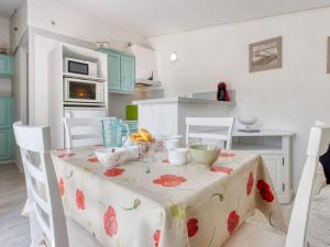 a kitchen with a table with a table cloth on it at Holiday Home Les Palombes-8 by Interhome in Lacanau-Océan