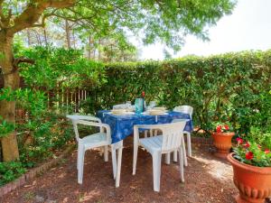 a blue table and chairs in a garden at Holiday Home Les Palombes-8 by Interhome in Lacanau-Océan