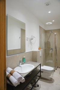 La salle de bains est pourvue d'un lavabo, d'une douche et de toilettes. dans l'établissement Hotel Credo, à Kotor