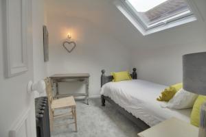 a bedroom with a bed and a table with a chair at Willow Cottage in Westerham
