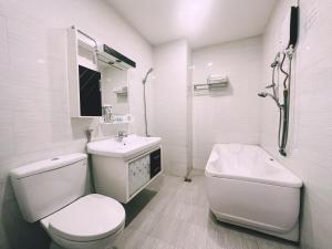 a white bathroom with a toilet and a sink at White Horse Dalat Hotel in Da Lat