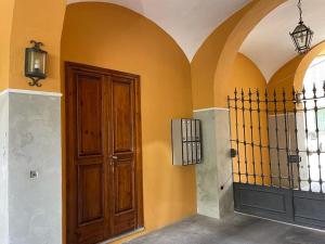 a hallway with a wooden door and a gate at Minimal Loft in centro a Piacenza in Piacenza