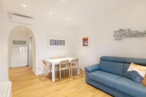 Una sala de estar con un sofá azul y una mesa. en Appartamento Amalfi - Elba, en Campo nell'Elba