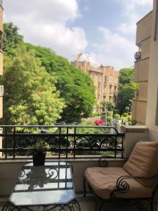 balcón con mesa, sillas y vistas a la ciudad en Spacious downtown Nile apartment, en El Cairo