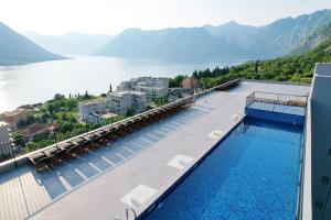 a swimming pool with a view of a body of water at Hotel Credo in Kotor