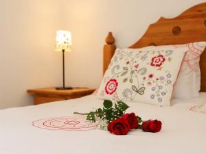 ナンダにあるApartment Domaine des Reines C10 by Interhomeの赤いバラが2本飾られたベッド
