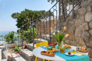 a table with food on it on a balcony at Villa Russo - De Vivo Realty Nerano in Nerano