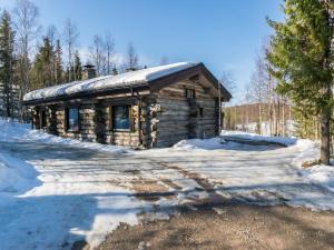 a log cabin in the snow with snow at Holiday Home Mustalampi 2 kurkiaura by Interhome in Ruka