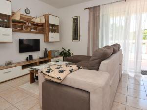 a living room with a couch and a television at Holiday Home Cici by Interhome in Iž Mali