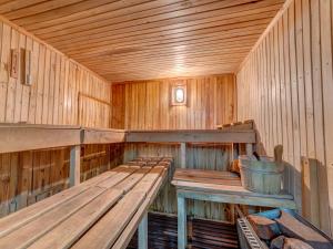 a wooden sauna with benches and a bucket in it at Holiday Home Hatale by Interhome in Rzyki