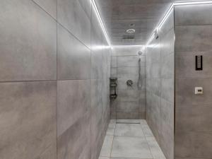 a bathroom with a shower and a tile wall at Holiday Home Hatale by Interhome in Rzyki