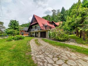dom z czerwonym dachem i kamiennym podjazdem w obiekcie Holiday Home Hatale by Interhome w mieście Rzyki