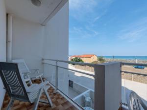 a balcony with a chair and a view of the ocean at Apartment Amphitrite by Interhome in Le Barcarès