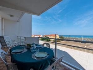 a table on a balcony with a view of the ocean at Apartment Amphitrite by Interhome in Le Barcarès