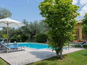 Villa con piscina, mesa y sombrilla en Holiday Home Olive Grove Sabina by Interhome, en Canneto
