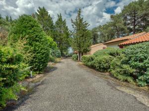 an empty road in front of a house with trees at Holiday Home Les As-10 by Interhome in Lacanau-Océan