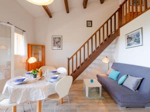 a living room with a table and a blue couch at Apartment Les Hauts des Issambres-1 by Interhome in La Garonnette-Plage