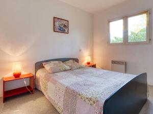 Un dormitorio con una cama y dos lámparas sobre mesas. en Chalet Picasso by Interhome, en Lacanau-Océan
