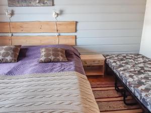 a bedroom with a bed and a wooden headboard at Holiday Home Mustalampi 5 satakieli by Interhome in Ruka