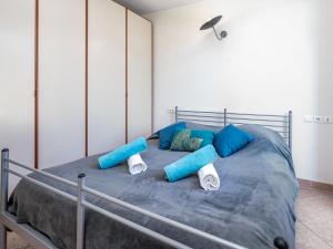 a bed with blue and white pillows on it at Apartment La Bouée by Interhome in Antibes