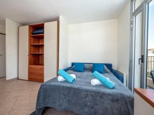 a bedroom with a blue bed with blue pillows at Apartment La Bouée by Interhome in Antibes