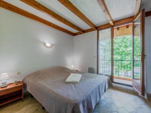 a bedroom with a bed and a large window at Holiday Home Le Lagon by Interhome in Saint-Cyprien-Plage