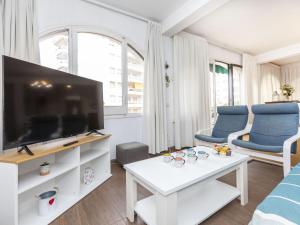 un salon avec une grande télévision et des fauteuils bleus dans l'établissement Holiday Home Platja by Interhome, à Lloret de Mar