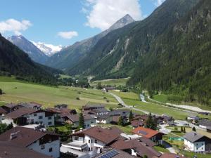a village in a valley with mountains in the background at Apartment Residence Awen-1 by Interhome in Neustift im Stubaital