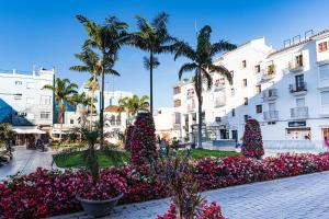 eine Straße mit Weihnachtsbäumen und Blumen vor einem Gebäude in der Unterkunft Acogedor apartamento en Estepona centro by Rent Me in Estepona