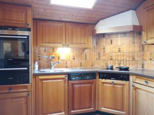 a kitchen with wooden cabinets and a sink at Chalet Les Clarines by Interhome in Grimentz