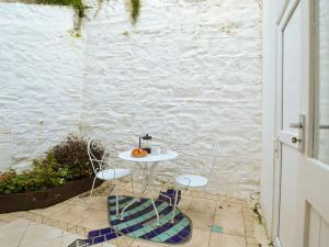 una mesa y dos sillas sentadas en un patio en Holiday Home Violet by Interhome en Looe
