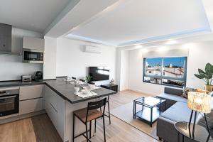 eine Küche und ein Wohnzimmer mit einem Tisch und einem Sofa in der Unterkunft Acogedor apartamento en Estepona centro by Rent Me in Estepona