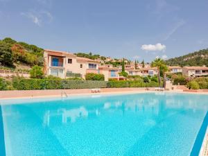 a large blue swimming pool in front of a house at Apartment Les Hauts des Issambres-12 by Interhome in Les Issambres