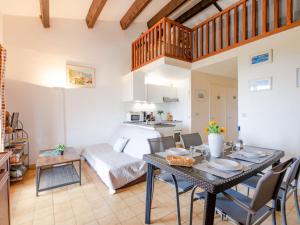 a living room with a dining room table and a kitchen at Apartment Les Hauts des Issambres-12 by Interhome in Les Issambres