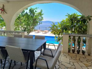 a table and chairs on a balcony with a view of the ocean at Holiday Home Stana by Interhome in Klenovica