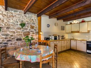 cocina con mesa y pared de piedra en Holiday Home Avel Vor - P, en Saint-Pol-de-Léon