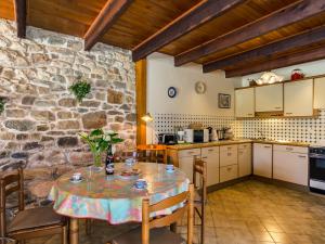 a kitchen with a table and a stone wall at Holiday Home Avel Vor by Interhome in Saint-Pol-de-Léon