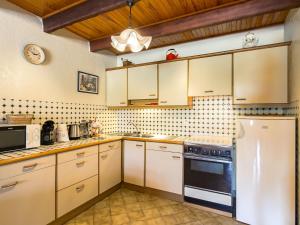 cocina con armarios blancos y nevera en Holiday Home Avel Vor - P, en Saint-Pol-de-Léon