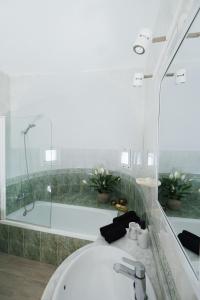 a white bathroom with a tub and a bath tub at Villa Sa Bassa, Amazing seaviews and great Pool in Portinatx