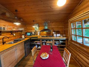 una cocina con una mesa roja en una cabaña en Chalet Birdieferienhaus by Interhome, en Leisel