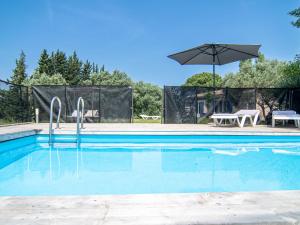 uma piscina com uma mesa e um guarda-sol em Holiday Home Les Oliviers - SAE110 by Interhome em Salernes