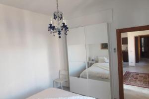 a bedroom with a mirror and a chandelier at Palazzo Altavilla Executive in Parma