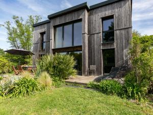 a wooden house with glass windows and a lawn at Chalet Ty Coat by Interhome in La Forêt-Fouesnant